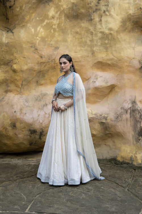 Devi Drape Ivory Mal Lehenga With Denim Halter Neck Embellished Blouse & Ivory Kota Doria Embellished Dupatta
