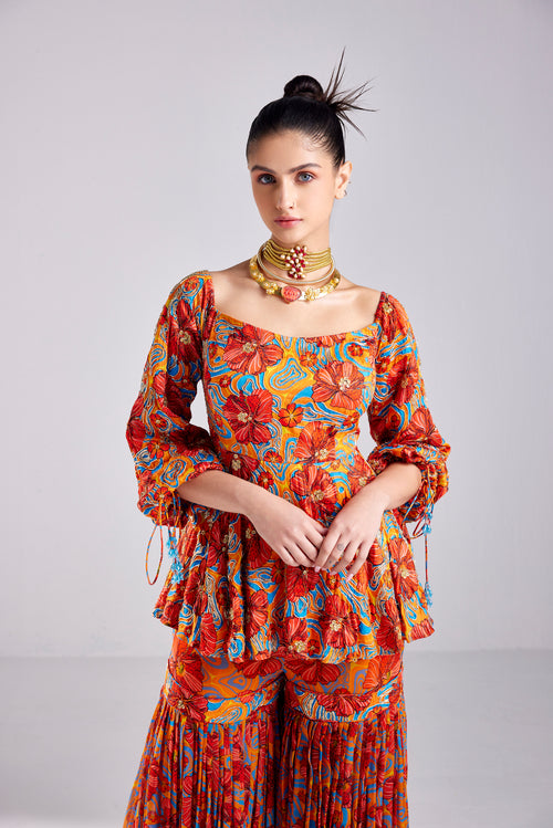 RUST FLORAL WAVE PRINT PEPLUM WITH RUST FLORAL WAVE PRINTED GHARARA PANTS