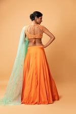 BRIGHT ORANGE LEHENGA WITH INTRICATE HANDWORK .