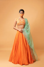 BRIGHT ORANGE LEHENGA WITH INTRICATE HANDWORK .