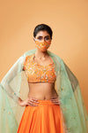 BRIGHT ORANGE LEHENGA WITH INTRICATE HANDWORK .