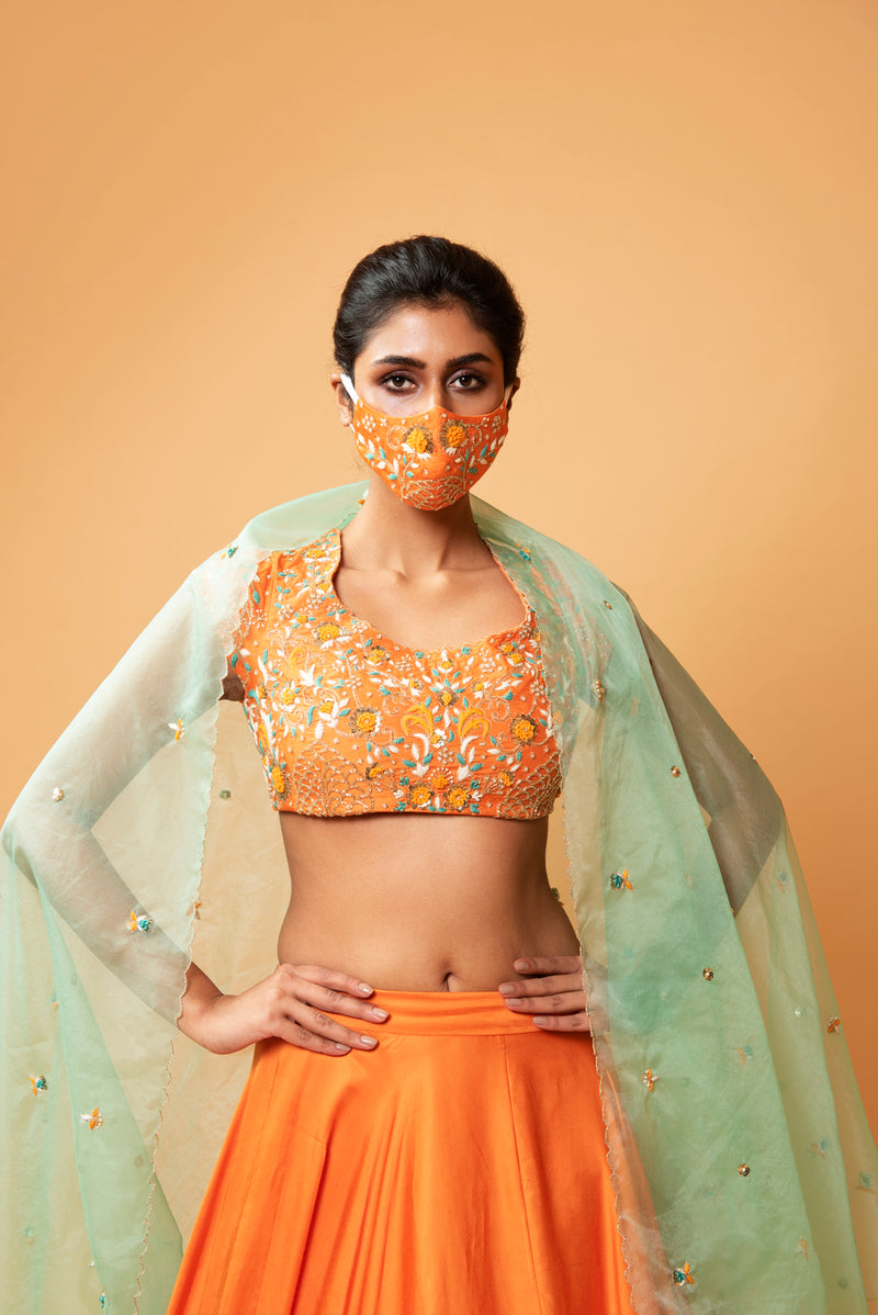 BRIGHT ORANGE LEHENGA WITH INTRICATE HANDWORK .