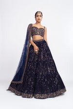 Navy blue corset blouse paired with dense dot lehenga.