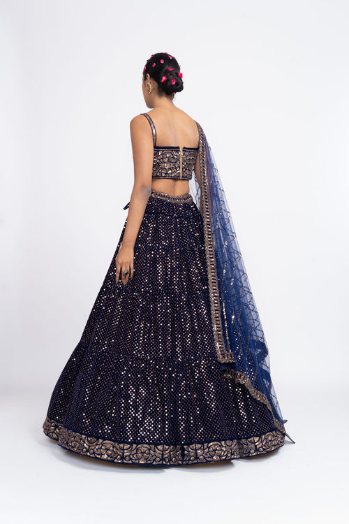 Navy blue corset blouse paired with dense dot lehenga.