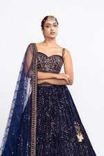 Navy blue corset blouse paired with dense dot lehenga.