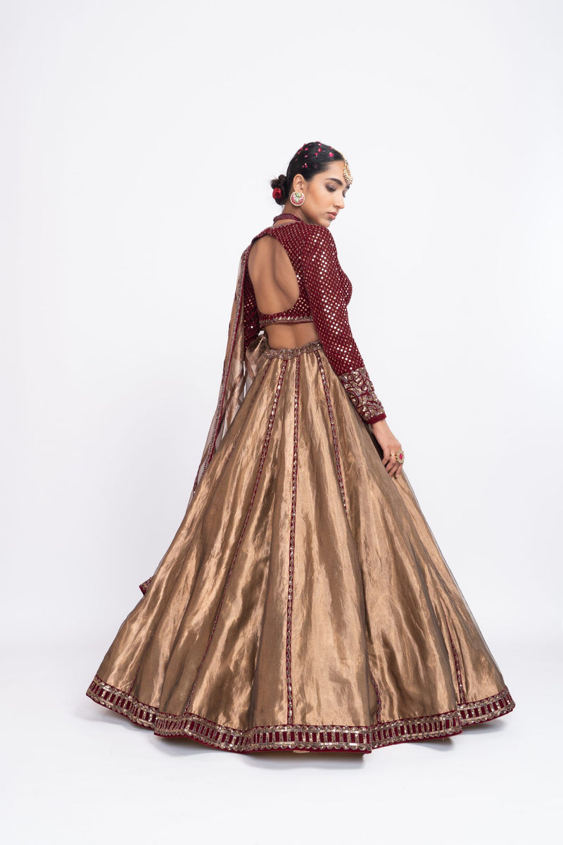 Mehroon embroidered blouse paired with copper tissue lehenga.