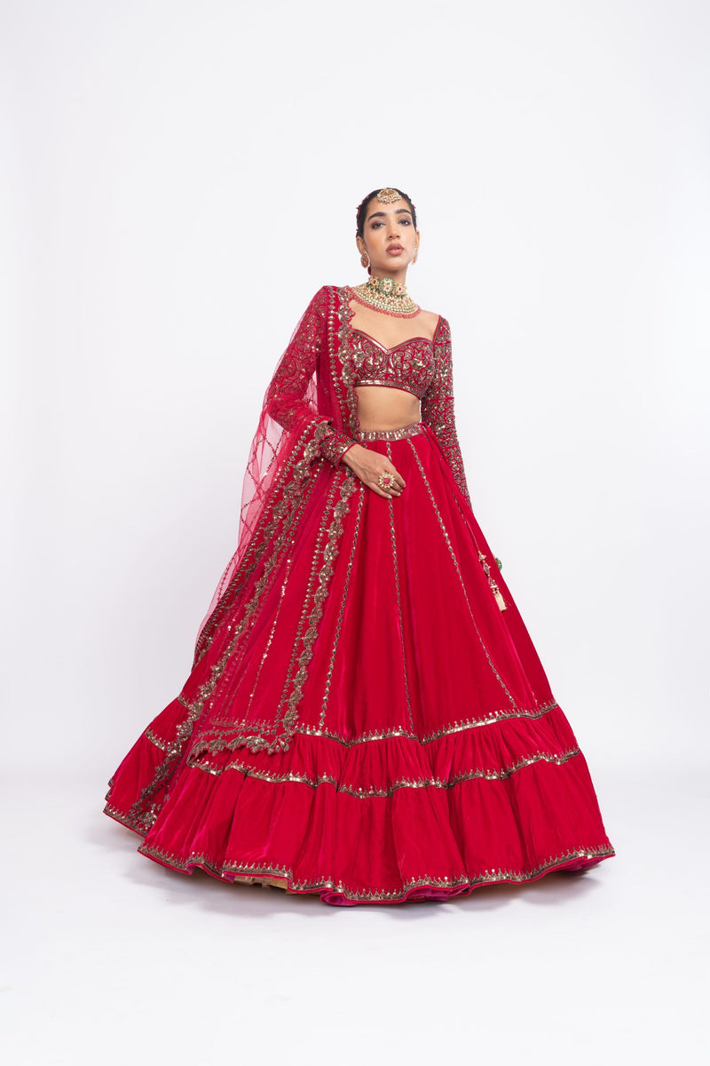 Red double-tier lehenga set with sweetheart neck and heavy full-sleeve blouse.