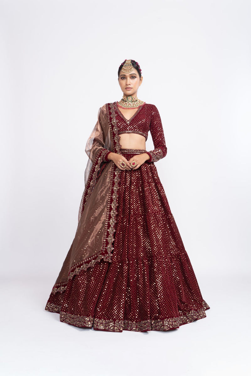 Mehroon dense dot full sleeve blouse paired up with dense dot lehenga.